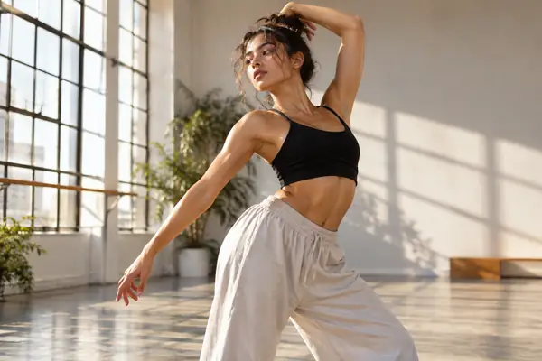 A dancer standing in a bright studio with a confident editorial pose.
